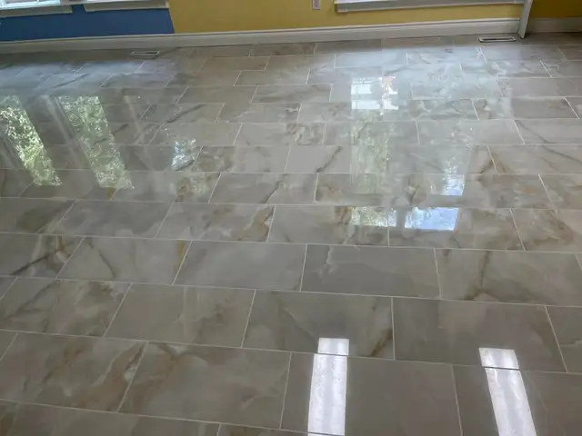 Polished marble-look porcelain floor tile reflecting window light in a large room